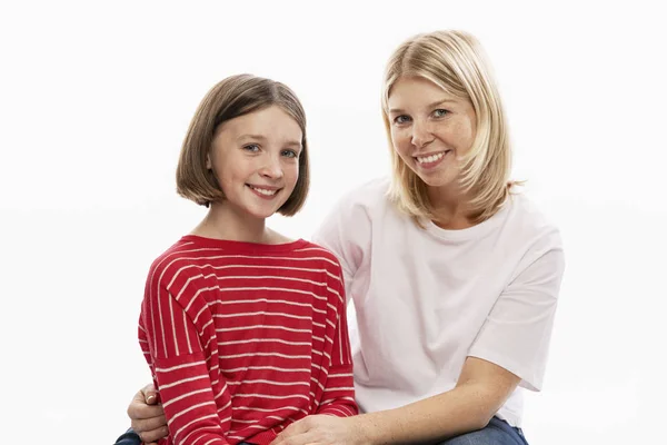 Junge Frau mit ihrer Teenager-Tochter umarmen und lächeln. Liebe und Zärtlichkeit. weißer Hintergrund. — Stockfoto