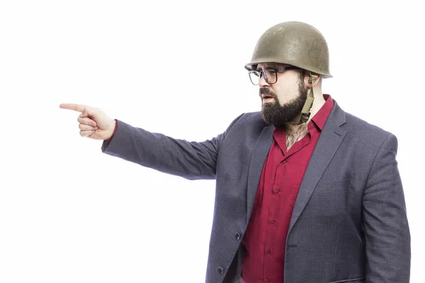 Un homme avec une barbe dans un casque militaire et en costume strict. Fond blanc . — Photo