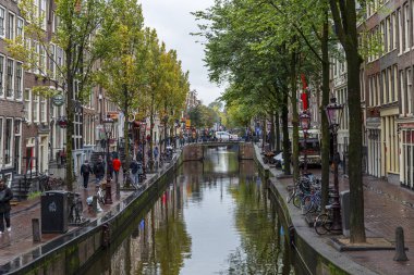 Amsterdam, Hollanda, 10 / 10 / 2019: Şehir merkezinde yürüyen insanlarla kanal.
