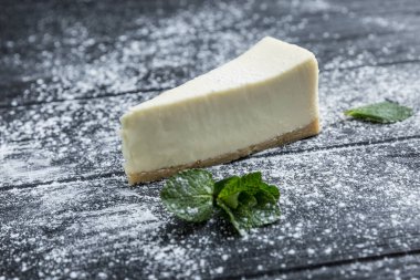 Koyu renk odunlarının üzerinde krema şekerli peynirli kek. Yakın plan..