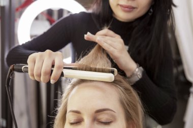 Güzellik salonunda saç stili yapan sarışın kız. Yakın plan..