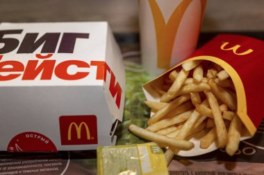 Moskova, Rusya, 03 / 26 / 2020: McDonald 's' tan alınmış öğle yemeği masanın üzerinde. Patates kızartması, büyük tortie burger ve içki. Yakın plan..