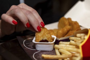 Kadın eli McIonalds 'da nugget yiyor. Yakın plan..