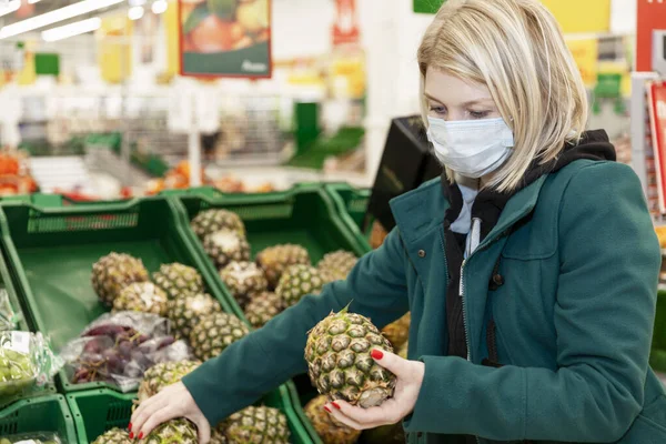 Mulher Loira Uma Máscara Médica Escolhe Frutas Supermercado Auto Isolamento — Fotografia de Stock