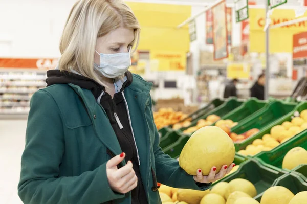 Mulher Loira Uma Máscara Médica Escolhe Frutas Supermercado Quarentena Durante — Fotografia de Stock