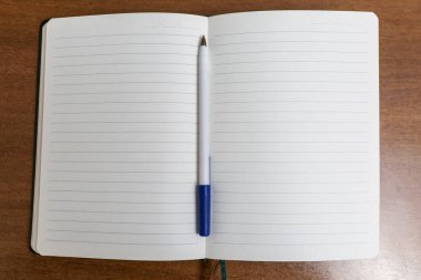 Ahşap bir masada kalemle açık günlük. Planlama ve organizasyon. Yukarıdan görüntüle.