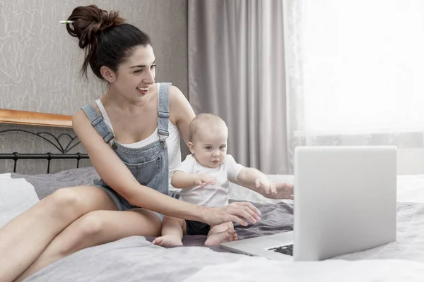 Happy Smiling Young Mother Small Child Works Home Sitting Bed — Stock Photo, Image