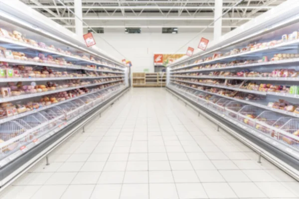 Shelves with chilled food in a supermarket. Space for text. Blurred.