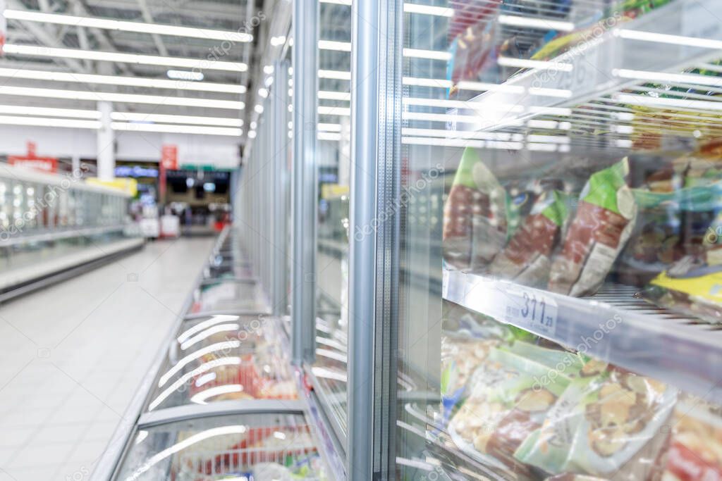 Shelves with frozen food in a supermarket. Space for text. Blurred.