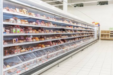 Süpermarkette soğutulmuş ürünlerin olduğu raflar. Bulanık. Metin için boşluk.