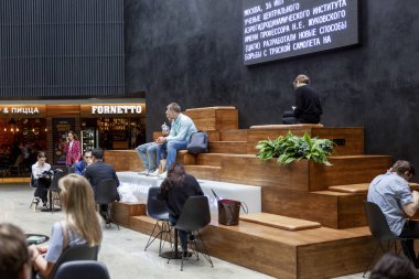 Moskova, Rusya, 07 / 16 / 2019: İnsanlar iş merkezindeki çağdaş bir dinlenme alanında oturuyorlar.