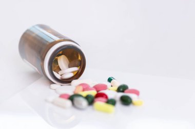 Farklı renk ve şekillerde beyaz arka plana yayılmış haplar. Dünya koronavirüs salgını. Yakın plan. İşaret fişeği. Metin için boşluk.