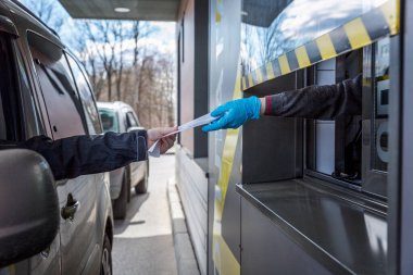 Moskova, Rusya, 04 / 26 / 2020: Bir araba sürücüsü bir McDonald 's fast food restoranının teslimat vitrininde fast food siparişi veriyor. Koronavirüs salgınının ortasında izolasyon döneminde popüler bir yer..