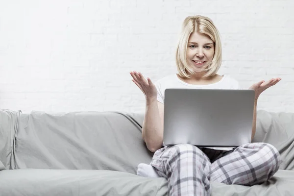 Blonde Woman Pajamas Sitting Gray Sofa Laptop Remote Work Training — Stock Photo, Image