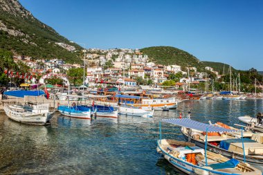 Kas, Türkiye, 05 / 16 / 2019: Dağlardaki küçük bir tatil beldesindeki güzel bir marinadaki yatlar ve küçük ahşap botlar. Turizm ve seyahat. Parlak güneşli bir gün.