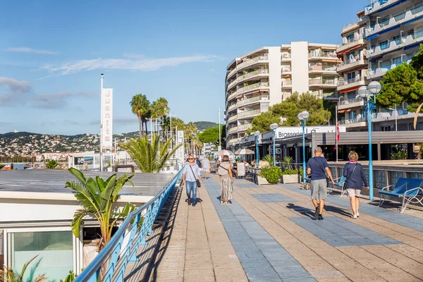 Juan Le Pen, Fransa, 10 / 06 / 2019: Turistler güneşli bir günde Cote d 'Azur üzerindeki tatil köyünün gezinti alanında yürüyorlar.