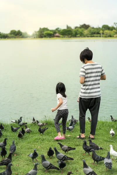 Mãe e criança alimentando peixes — Fotografia de Stock