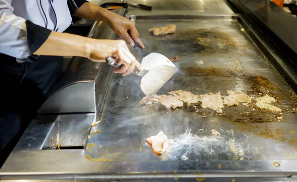 Mão de Chef cozinhar bife de porco na panela quente — Fotografia de Stock