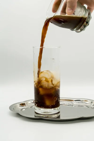 Pouring coffee into a glass of ice — Stock Photo, Image