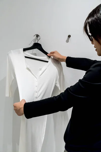 Woman looking at white clothes