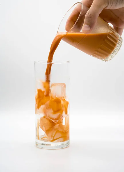 Pouring Thai Milk Tea into a glass with ice — Stock Photo, Image