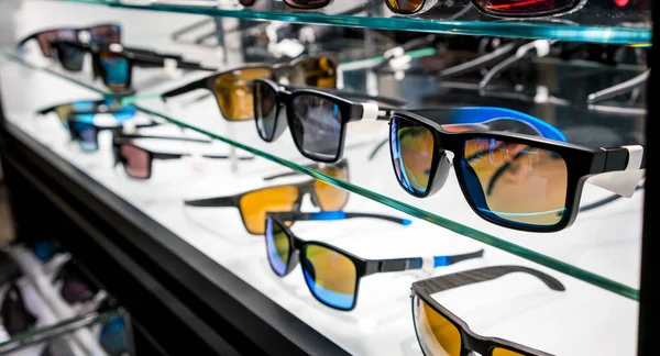 Různé sluneční brýle v obchodě zobrazovat police — Stock fotografie