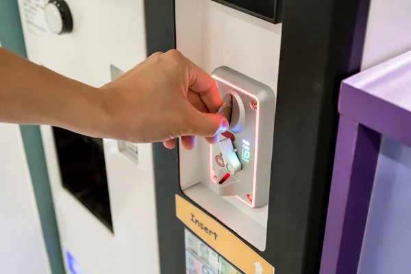 Mujer mano insertando monedas en la máquina expendedora — Foto de Stock