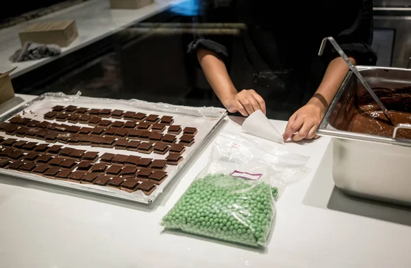 Pastelaria chef mãos fazendo um cone de papel para decoração de chocolate — Fotografia de Stock