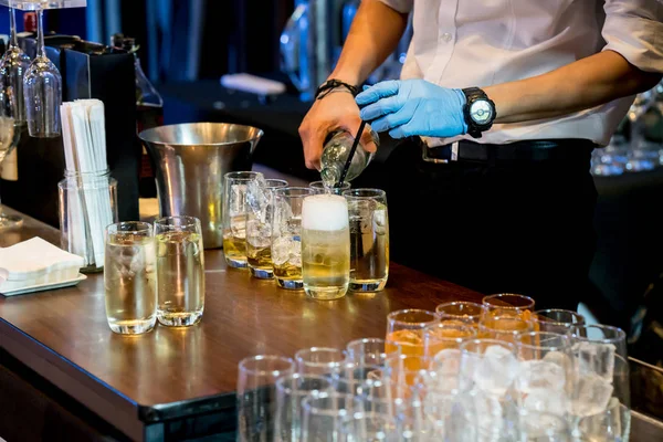 Barman mão derramando refrigerante clube no gelo e uísque — Fotografia de Stock