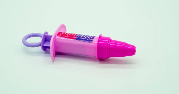 Pink plastic syringe of doctor and nurse play set — Stock Photo, Image