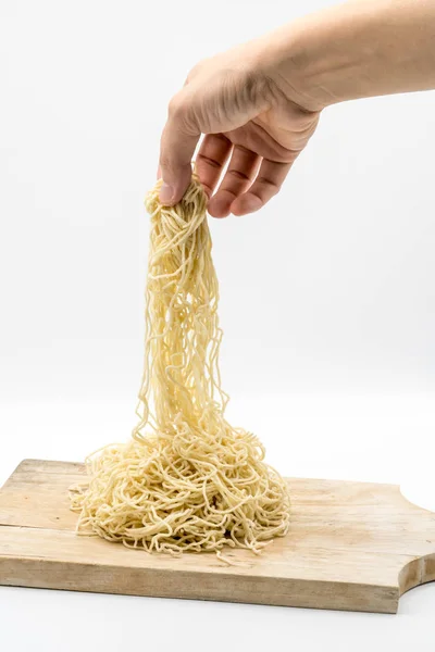 Hand trekken ongekookt ei noodle van houten plank — Stockfoto