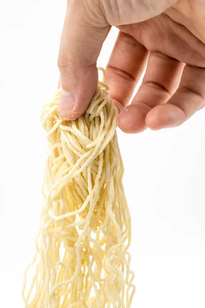 Cerrado mano tirando de fideos de huevo sin cocer — Foto de Stock