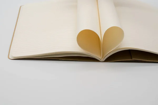 Notebook se stránkami, které jsou složeny do srdce izolovaných na bílém pozadí — Stock fotografie