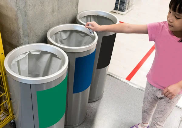 Niña asiática poniendo papel usado en la papelera reciclada. Diferente — Foto de Stock