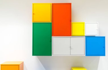 Beyaz duvarda asılı renkli metal dolaplar