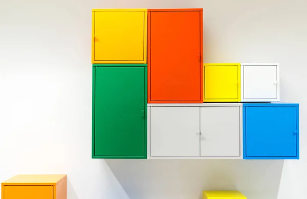 Colorful metal cabinets hanging on white wall