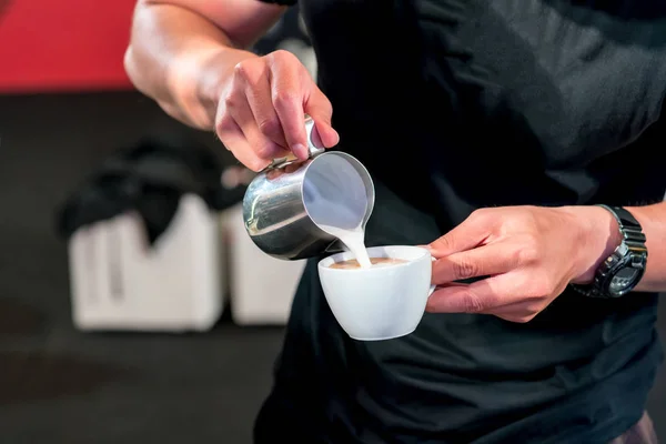Рука бариста заливає піну свіжого молока в чашку еспресо — стокове фото