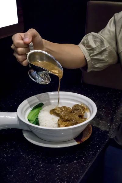 Verter a mano salsa de carne de res estofada sobre arroz con carne estofada — Foto de Stock