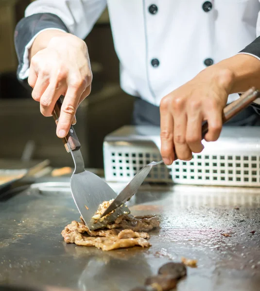 Рука шеф-кухаря готує яловичий стейк на гарячій сковороді перед клієнтами — стокове фото