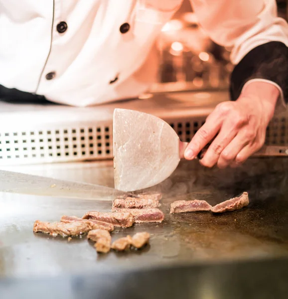 Szakács főzés a forró serpenyőben előtt a vevők marhahús steak keze — Stock Fotó