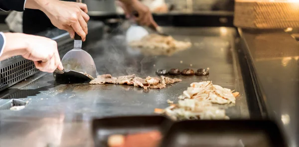 Szakács főzés a forró serpenyőben előtt a vevők marhahús steak keze — Stock Fotó