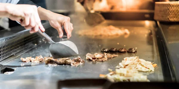 El müşterilerinin önünde sıcak tava sığır eti biftek pişirme Şef