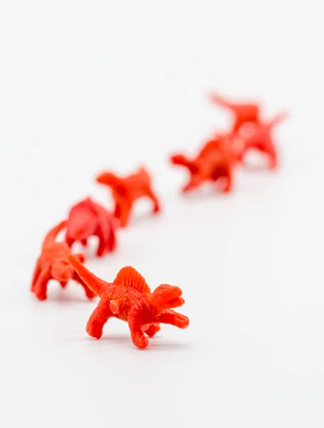 Eine Gruppe roter Spielzeug-Dianosaurier isoliert auf weiß — Stockfoto