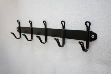 Siyah metal duvar askı beyaz duvara monte.