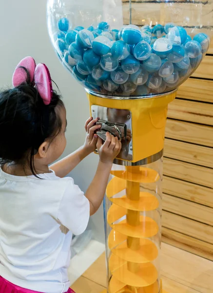 Азиатка играет в счастливую ничью из автомата по продаже мячей . — стоковое фото