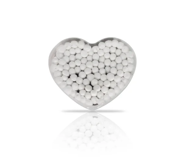 Botões de algodão em um recipiente de plástico em forma de coração — Fotografia de Stock