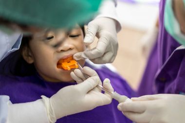 Asyalı kız dişçi rutin diş check-up ve fluori için bir araya geldi