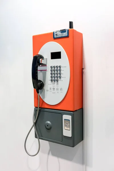 Оранжевый старинный телефон-автомат — стоковое фото