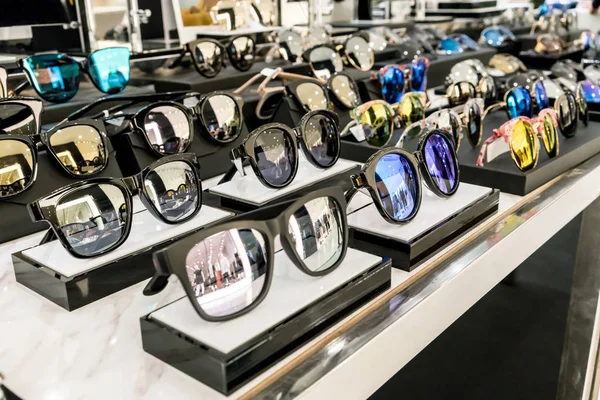 Varios de gafas de sol en los estantes de exhibición de la tienda . — Foto de Stock