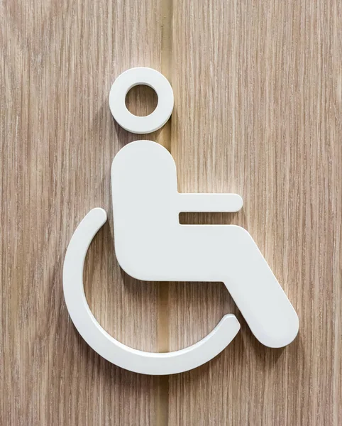 Disabilitare persona segno per bagno in bianco contro backgro in legno — Foto Stock